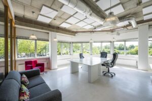Modern en licht kantoorpand aan de Anthony Fokkerweg met grote ramen, vergadertafel en loungehoek.